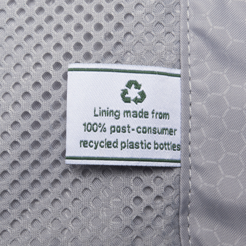 close-up view of the interior lining on the teal travelpro maxlite® air v2 hardside luggage, showing a white fabric label that reads "lining made from 100% post-consumer recycled plastic bottles" next to a grey mesh pocket.