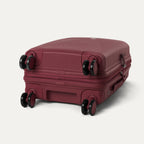 bottom view of the tibetan red travelpro optima® expandable carry-on hardside spinner, showing the four 360-degree self-aligning spinner wheels and the protective polypropylene base.
