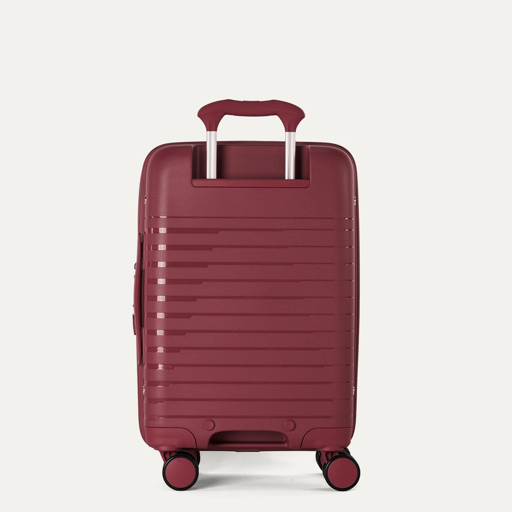 rear view of the tibetan red travelpro optima® expandable carry-on hardside spinner, showing the ribbed polypropylene shell and the color-matched powerscope extension handle with contour grip.