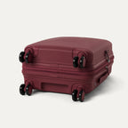 bottom view of the tibetan red travelpro optima® expandable compact carry-on hardside spinner, showing the four 360-degree self-aligning spinner wheels and the protective polypropylene base.