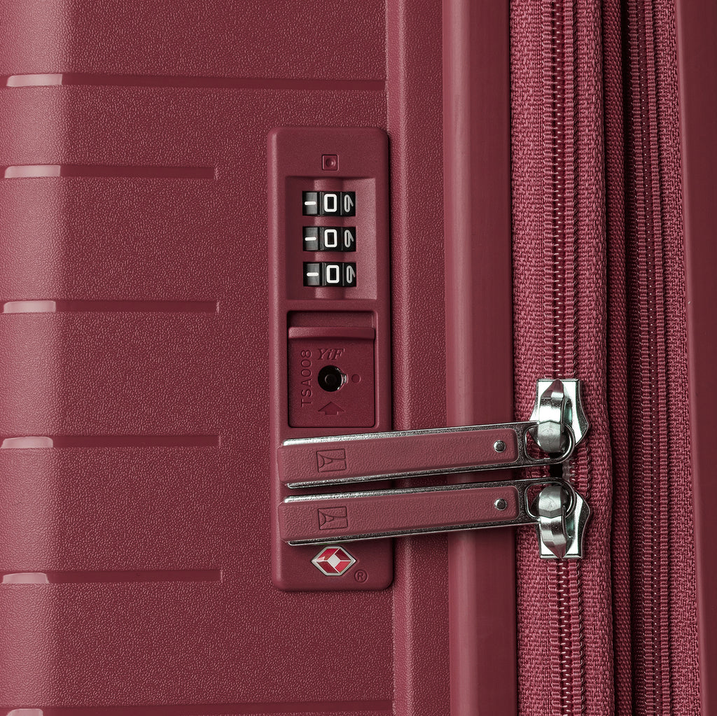 close-up view of the integrated tsa-approved combination lock on the tibetan red travelpro optima® hardside compact carry-on, showing the color-matched lock housing and metal zipper pulls securely locked into place.
