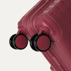 close-up view of the 360-degree self-aligning spinner wheels on the tibetan red travelpro optima® expandable compact carry-on, showing the color-matched wheel hubs and dual-wheel design.