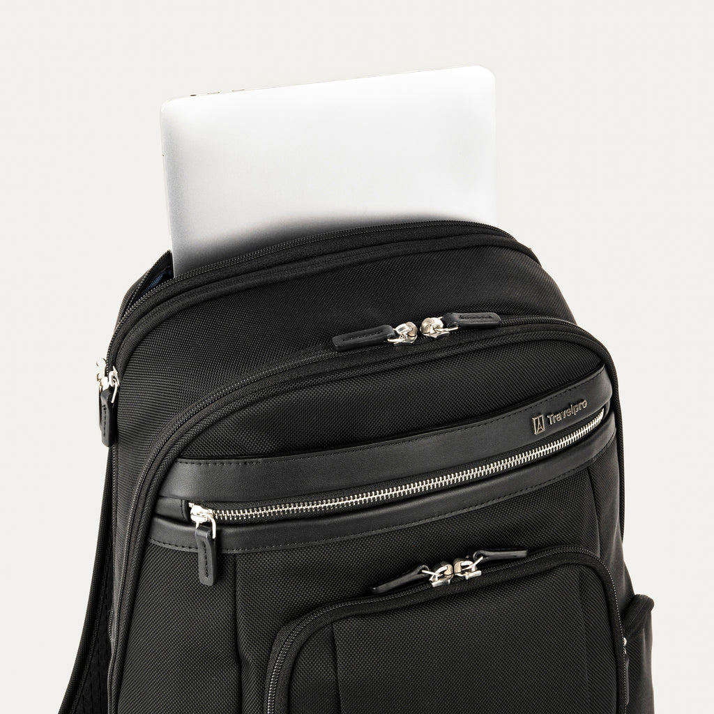 close-up view of the black travelpro platinum elite business laptop backpack 27l, showing a white tablet being tucked into the dedicated padded electronics sleeve located at the top of the main compartment.