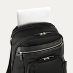 close-up view of the black travelpro platinum elite business laptop backpack 27l, showing a white tablet being tucked into the dedicated padded electronics sleeve located at the top of the main compartment.