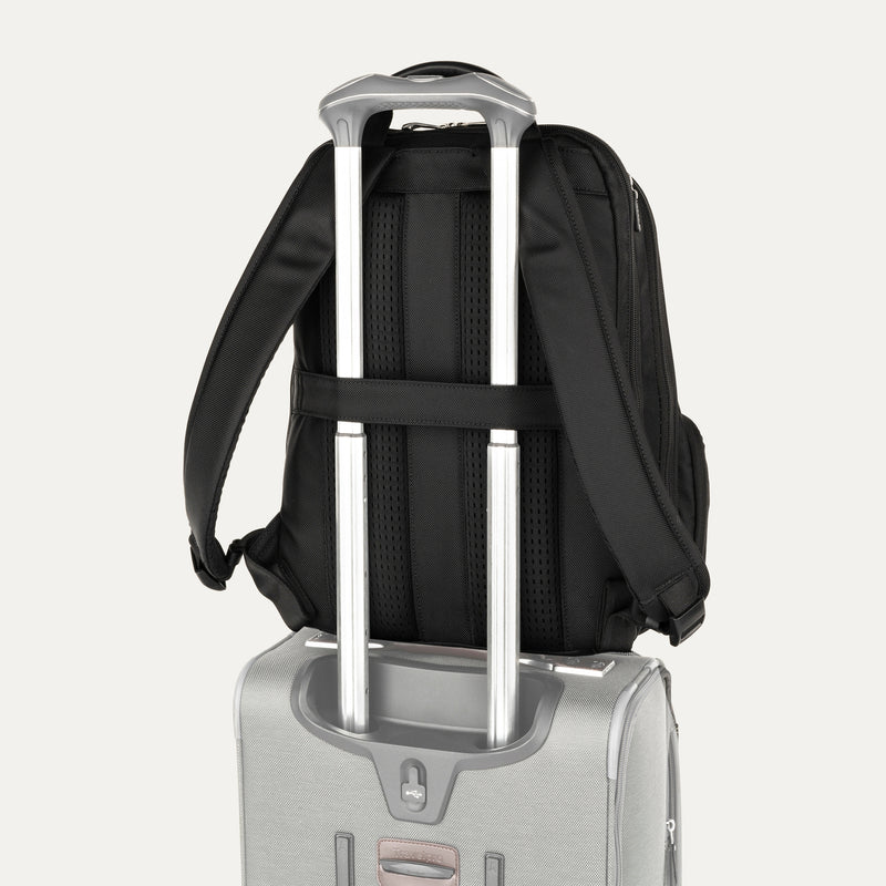 rear view of the black travelpro platinum elite business laptop backpack 27l stacked on a silver hardside suitcase, showing the integrated trolley strap slid over the luggage handle for secure travel.