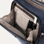 interior view of the front organizational compartment of the true navy travelpro platinum elite business laptop backpack 27l, showing built-in pockets for pens, a key tether, and a small zippered security pocket against a light-colored lining.