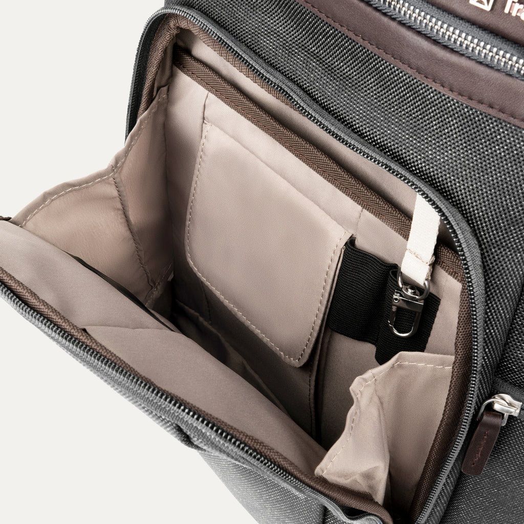 interior view of the front organizational compartment of the vintage grey travelpro platinum elite business laptop backpack 27l, showing built-in pockets for pens, a key tether, and a small zippered security pocket.