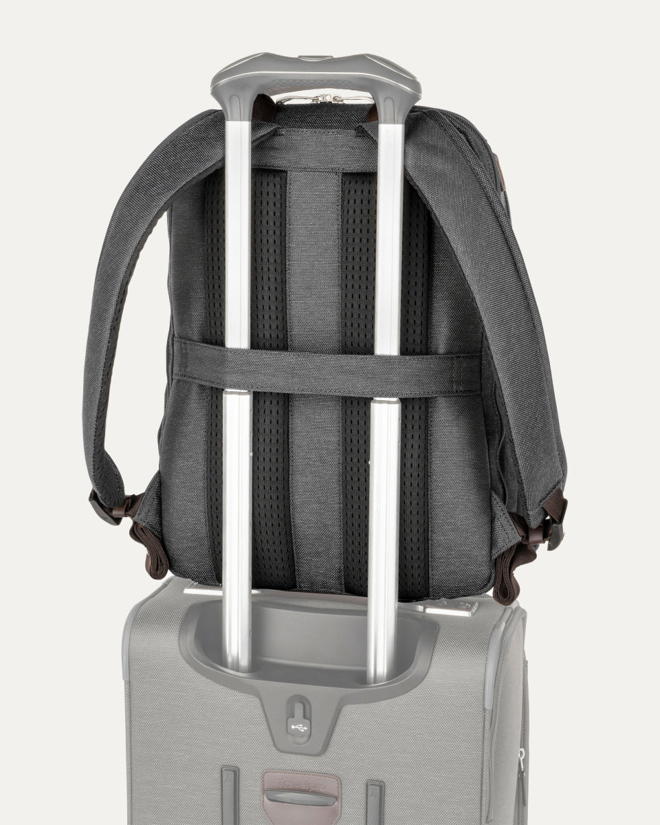 rear view of the vintage grey travelpro platinum elite business laptop backpack 27l stacked on a grey rolling suitcase, showing the integrated trolley strap secured over the handle for easy transport.