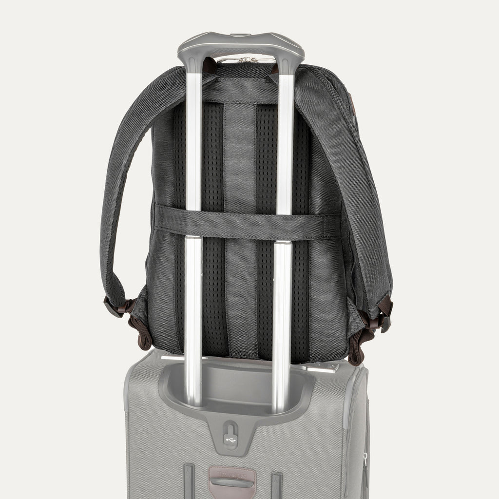 rear view of the vintage grey travelpro platinum elite business laptop backpack 27l stacked on a grey rolling suitcase, showing the integrated trolley strap secured over the handle for easy transport.