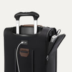 close-up of the shadow black travelpro platinum elite compact carry-on featuring a white usb cable plugged into the external charging port and a power bank stored in the dedicated exterior battery pocket.