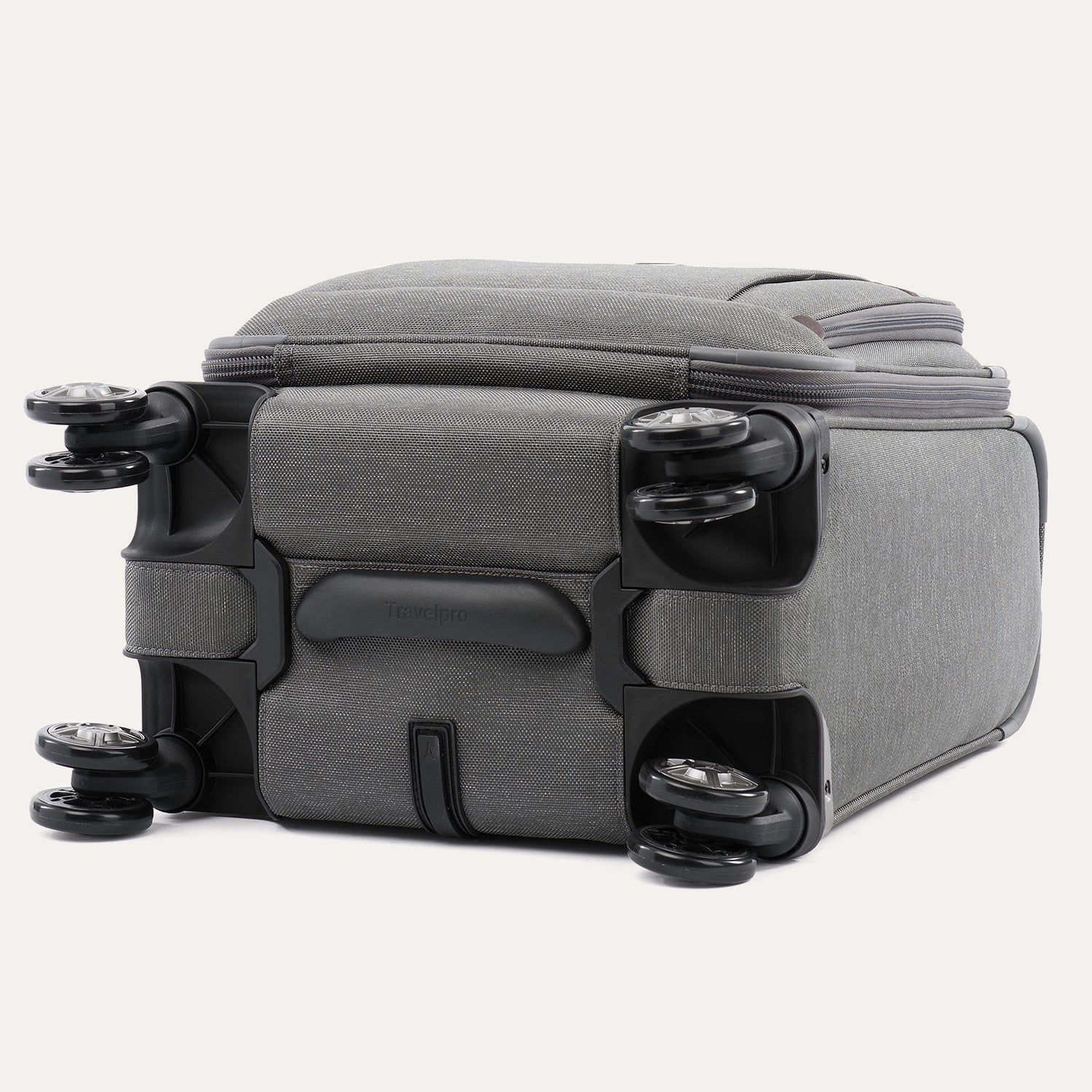 bottom view of the vintage grey travelpro platinum® elite carry-on spinner tote, showing the four high-performance magnatrac® self-aligning spinner wheels, the protective bottom molding with the travelpro logo, and the durable fabric base.