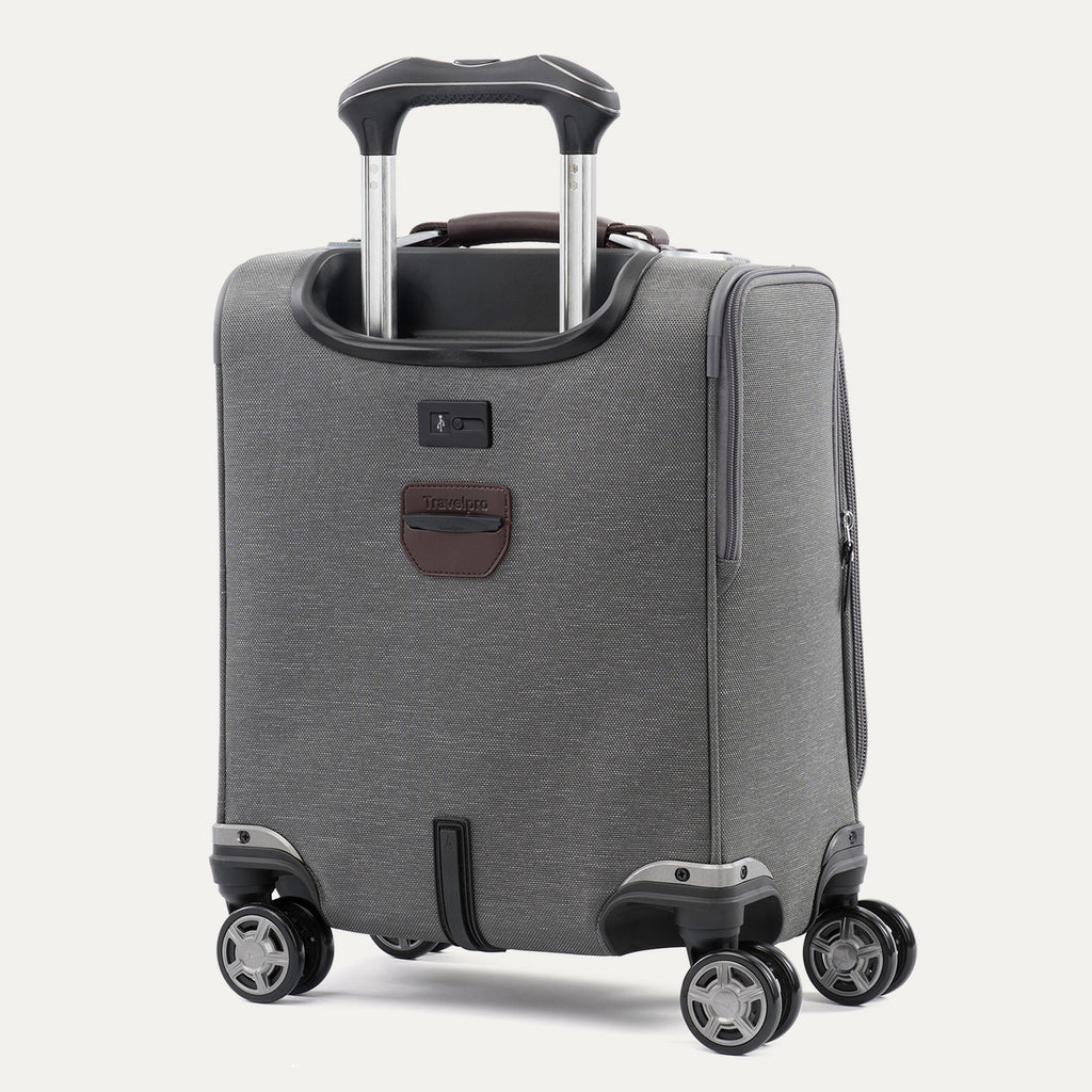 rear-angled view of the vintage grey travelpro platinum® elite carry-on spinner tote, showing the integrated trolley strap for stacking on luggage, the external usb port, and high-performance magnatrac® self-aligning spinner wheels.