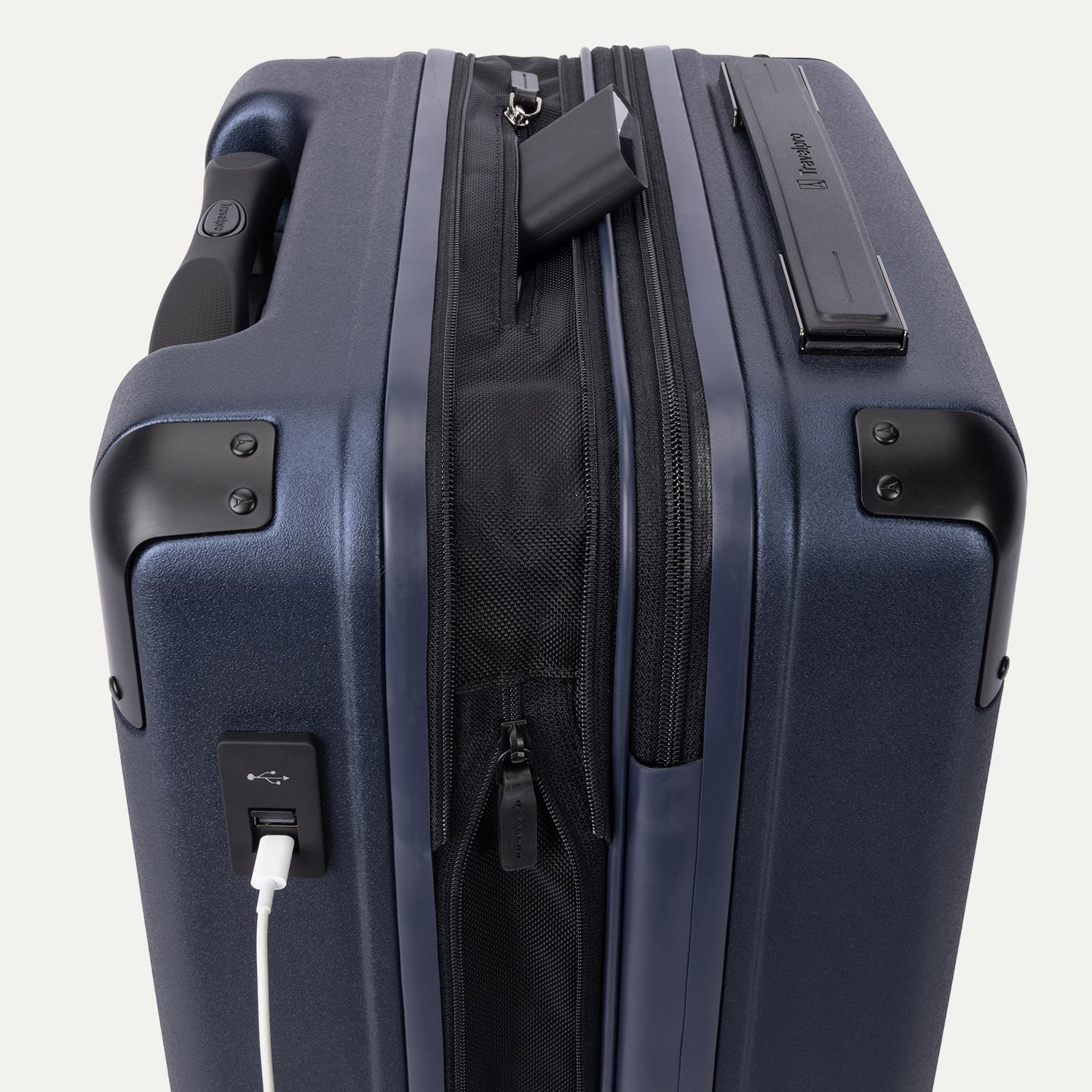 close-up of the external usb-a and usb-c charging ports on the travelpro platinum elite compact carry-on hardside spinner in aviator navy, showing a power bank tucked into the dedicated battery sleeve within the expansion gusset.