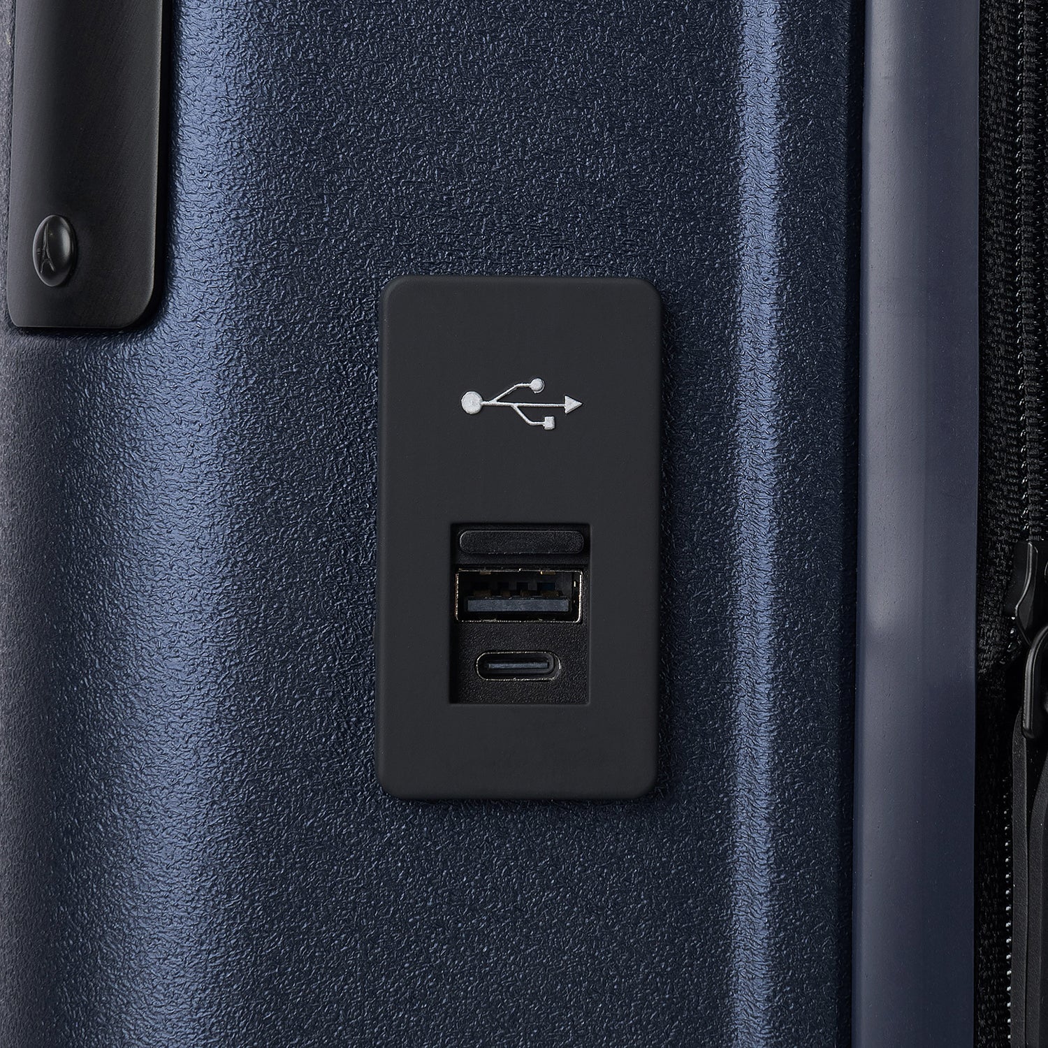 macro detail view of the external usb-a and usb-c charging ports on the travelpro platinum elite compact carry-on hardside spinner in aviator navy, highlighting the integrated power connectivity.