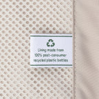 macro detail of the ecofab™ interior lining on the travelpro platinum elite compact carry-on hardside spinner in dark sky blue, featuring a tag that reads "lining made from 100% post-consumer recycled plastic bottles."