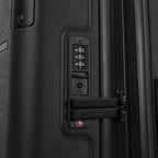 Close-up of the integrated TSA-approved combination lock on the Travelpro Platinum Elite Compact Carry-On Hardside Spinner in Shadow Black, showing the dual zipper pulls securely locked into the mechanism.