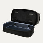 interior view of the open drop-bottom compartment on the black travelpro platinum elite weekender bag, showing the spacious empty section with a grey lining and internal snap-button compression straps.