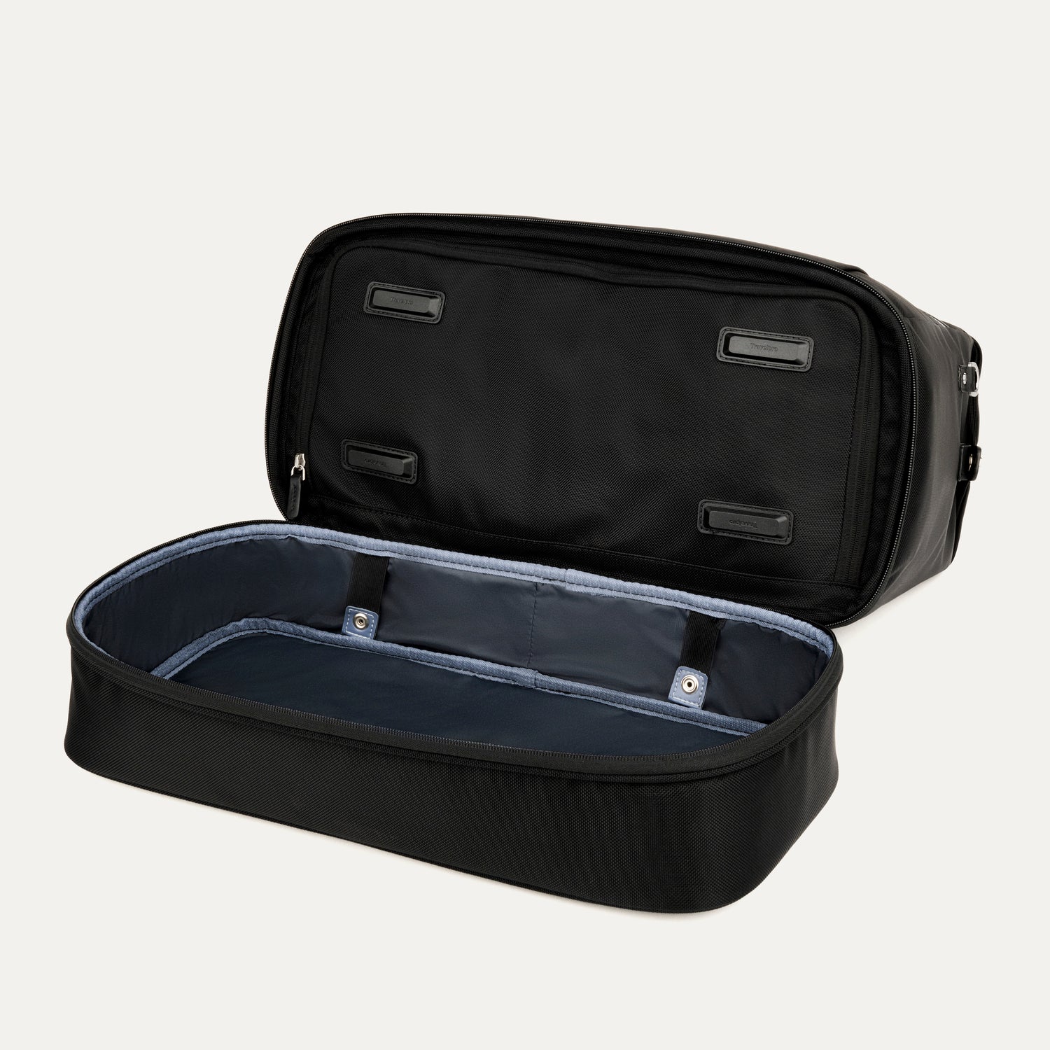interior view of the open drop-bottom compartment on the black travelpro platinum elite weekender bag, showing the spacious empty section with a grey lining and internal snap-button compression straps.