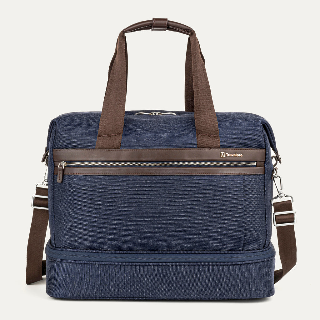 front view of the true navy travelpro platinum elite drop-bottom weekender bag, featuring its signature two-compartment design with premium brown leather trim, chrome zippers, and a removable shoulder strap.