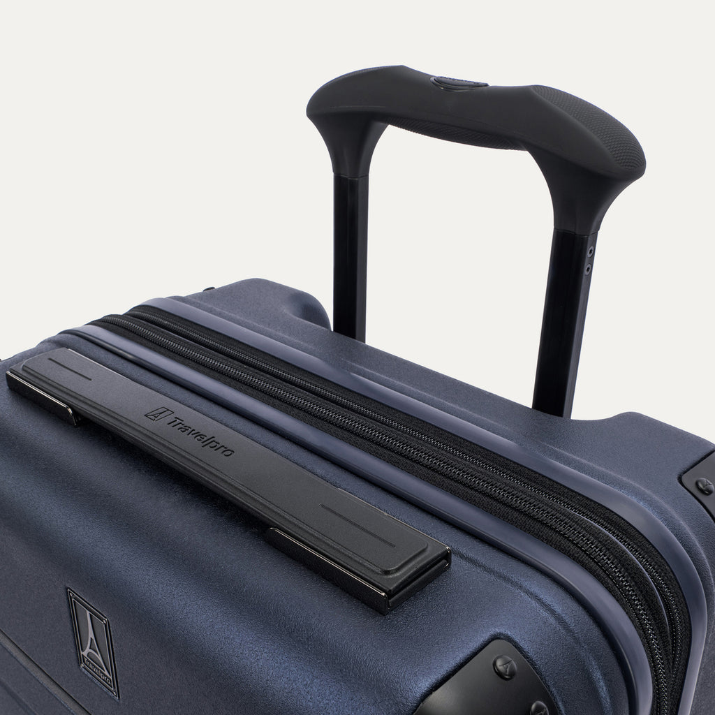 Close-up detail of the Travelpro Platinum Elite Carry-On Hardside Spinner in Aviator Navy, featuring the rubberized Contour Grip on the multi-stop PowerScope Lite handle and the sleek top carry handle.