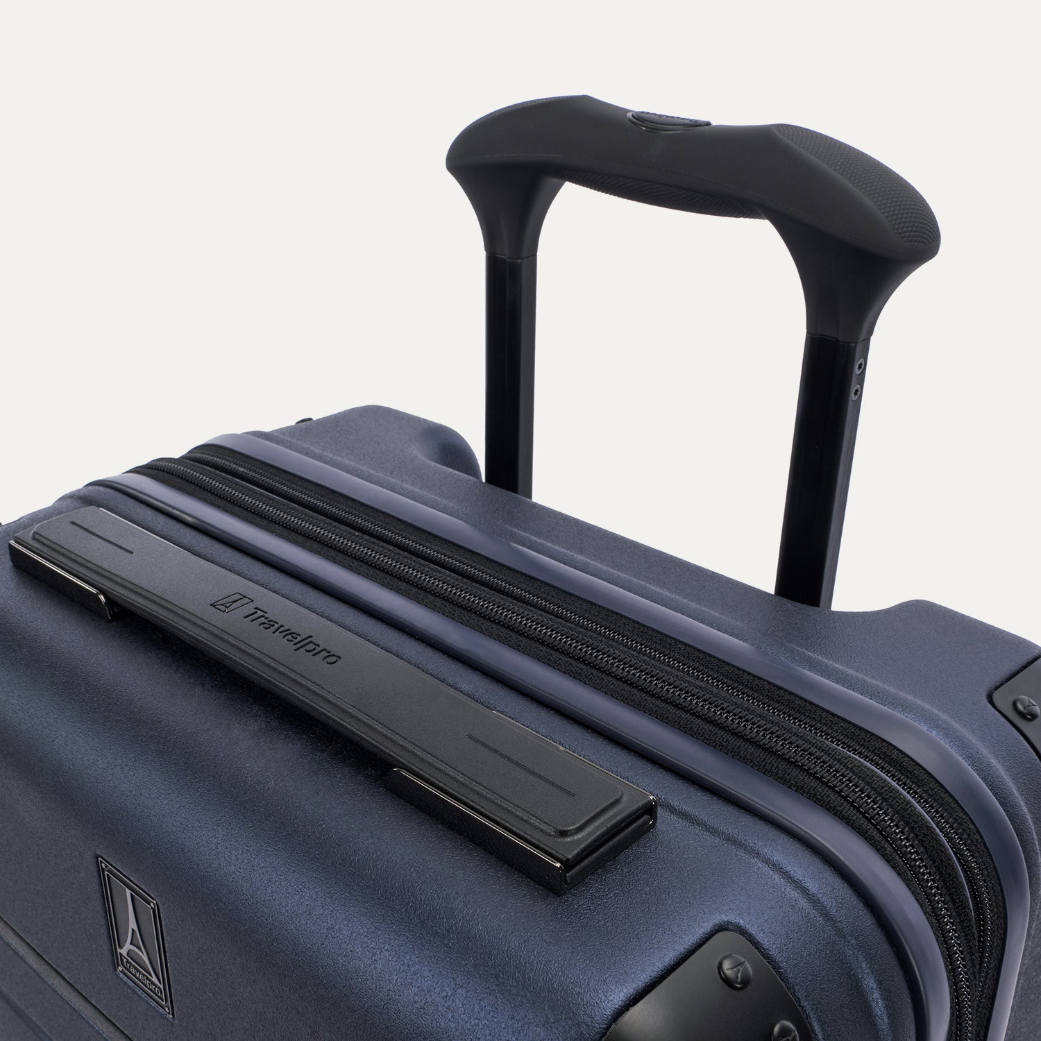 Close-up detail of the Travelpro Platinum Elite Carry-On Hardside Spinner in Aviator Navy, featuring the rubberized Contour Grip on the multi-stop PowerScope Lite handle and the sleek top carry handle.