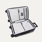 Interior packing view of the Travelpro Platinum Elite Carry-On Hardside Spinner in Aviator Navy, featuring dual zippered divider panels and the ECOFAB™ lining made from 100% recycled plastic bottles.
