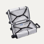 Open interior view of the empty Travelpro Platinum Elite Carry-On Hardside Spinner in Aviator Navy, showcasing the premium lining, dual packing compartments, and integrated tie-down straps.