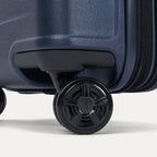 Close-up of the high-performance spinner wheels on the Travelpro Platinum Elite Carry-On Hardside Spinner in Aviator Navy, featuring self-aligning MagnaTrac® technology for effortless 360-degree mobility.