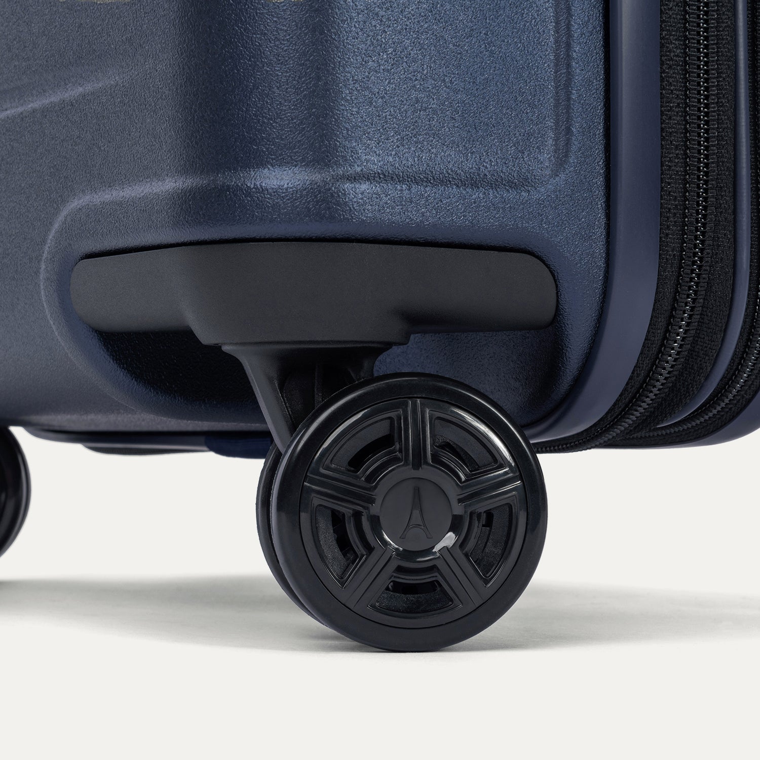 Close-up of the high-performance spinner wheels on the Travelpro Platinum Elite Carry-On Hardside Spinner in Aviator Navy, featuring self-aligning MagnaTrac® technology for effortless 360-degree mobility.