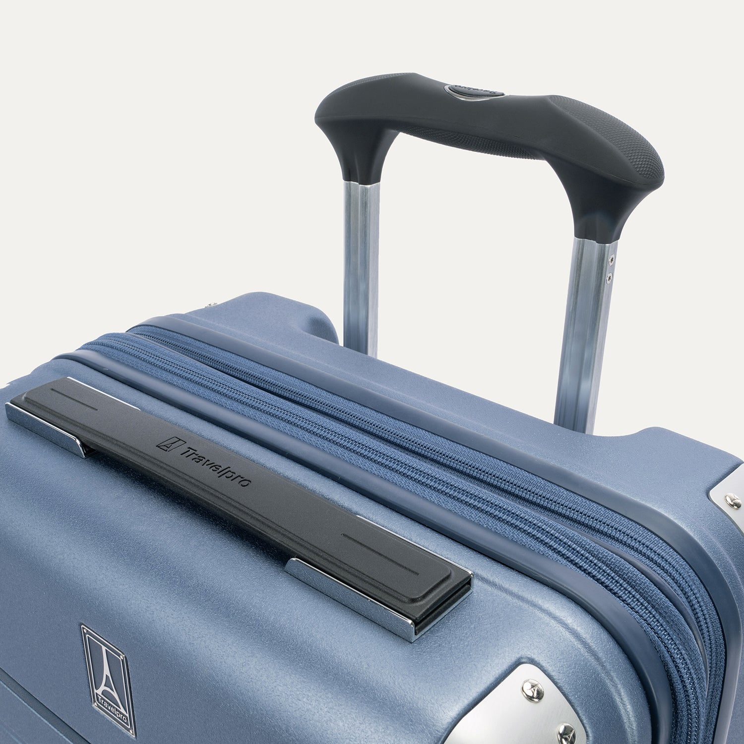 Close-up detail of the Travelpro Platinum Elite Carry-On Hardside Spinner in Dark Sky Blue, featuring the rubberized Contour Grip on the multi-stop PowerScope Lite handle and the sleek, chrome-trimmed top carry handle.