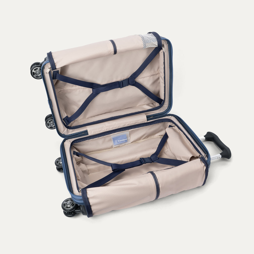 Open interior view of the empty Travelpro Platinum Elite Carry-On Hardside Spinner in Dark Sky Blue, showcasing the premium lining, dual packing compartments, and integrated tie-down straps.