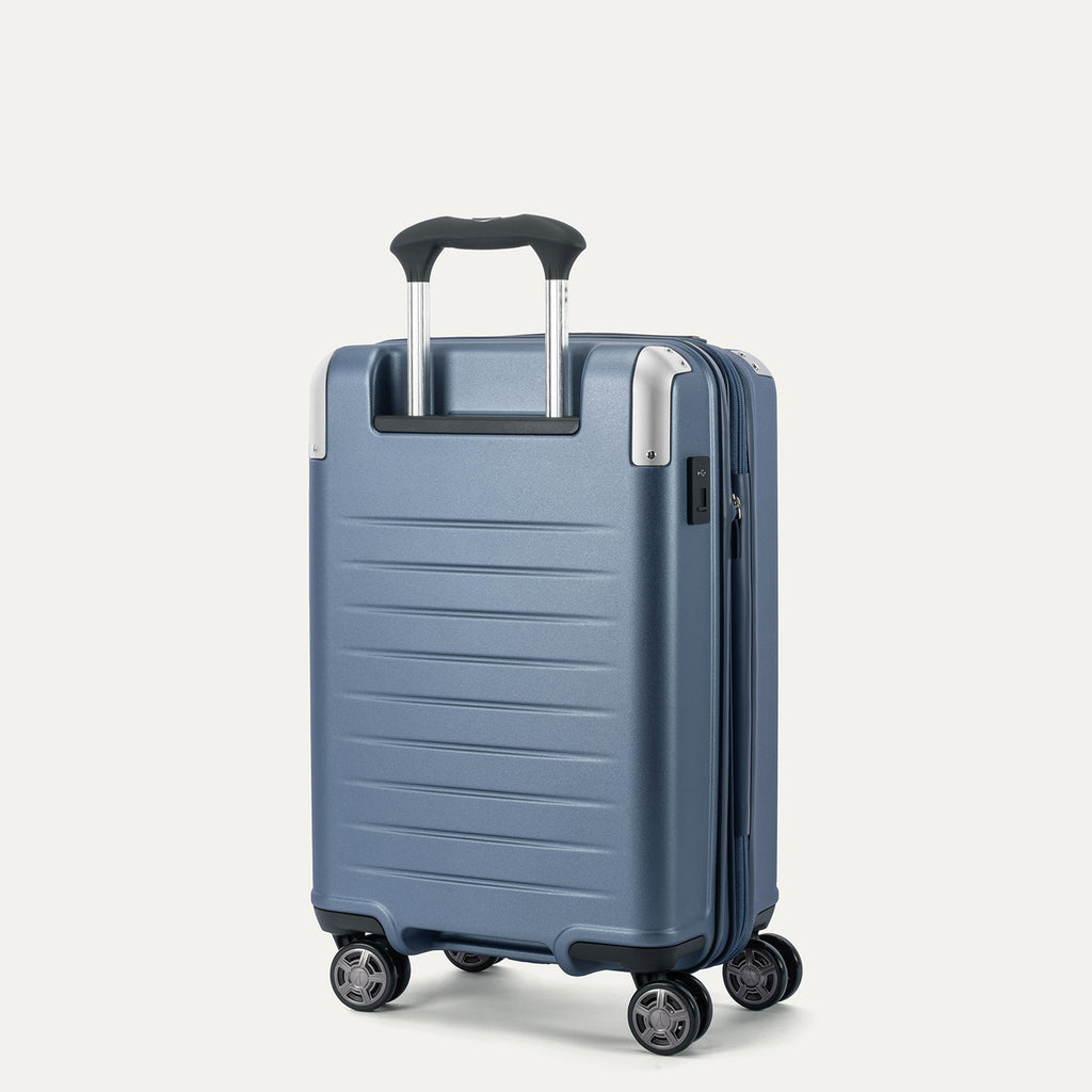 Rear 3/4 view of the Travelpro Platinum Elite Carry-On Hardside Spinner in Dark Sky Blue, featuring the adjustable PowerScope Lite handle and high-performance, self-aligning spinner wheels.