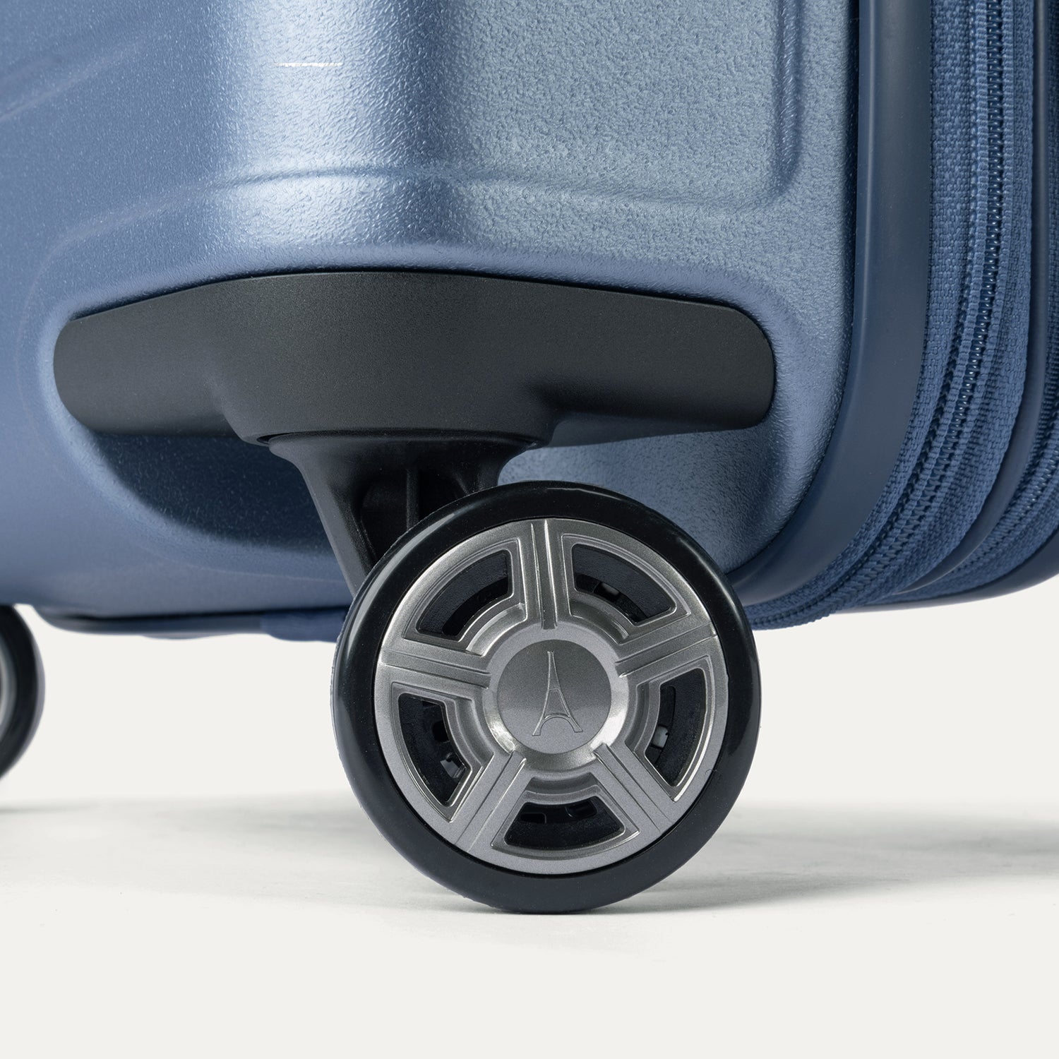 Close-up of the high-performance spinner wheels on the Travelpro Platinum Elite Carry-On Hardside Spinner in Dark Sky Blue, featuring self-aligning MagnaTrac® technology for effortless 360-degree mobility.