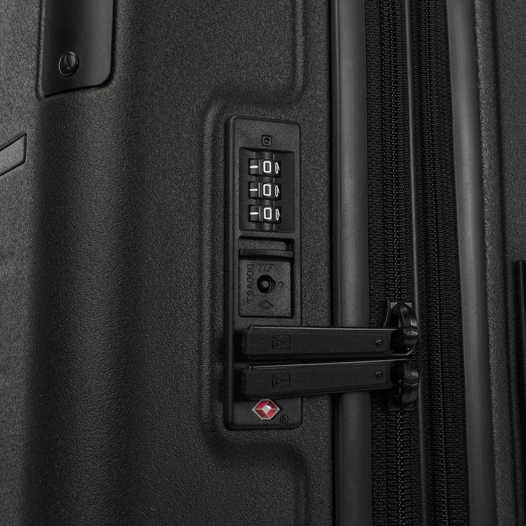 Close-up detail of the Travelpro Platinum Elite Carry-On Hardside Spinner in Jet Black, showing the integrated TSA-approved combination lock and secure zipper pulls on the durable polycarbonate shell.
