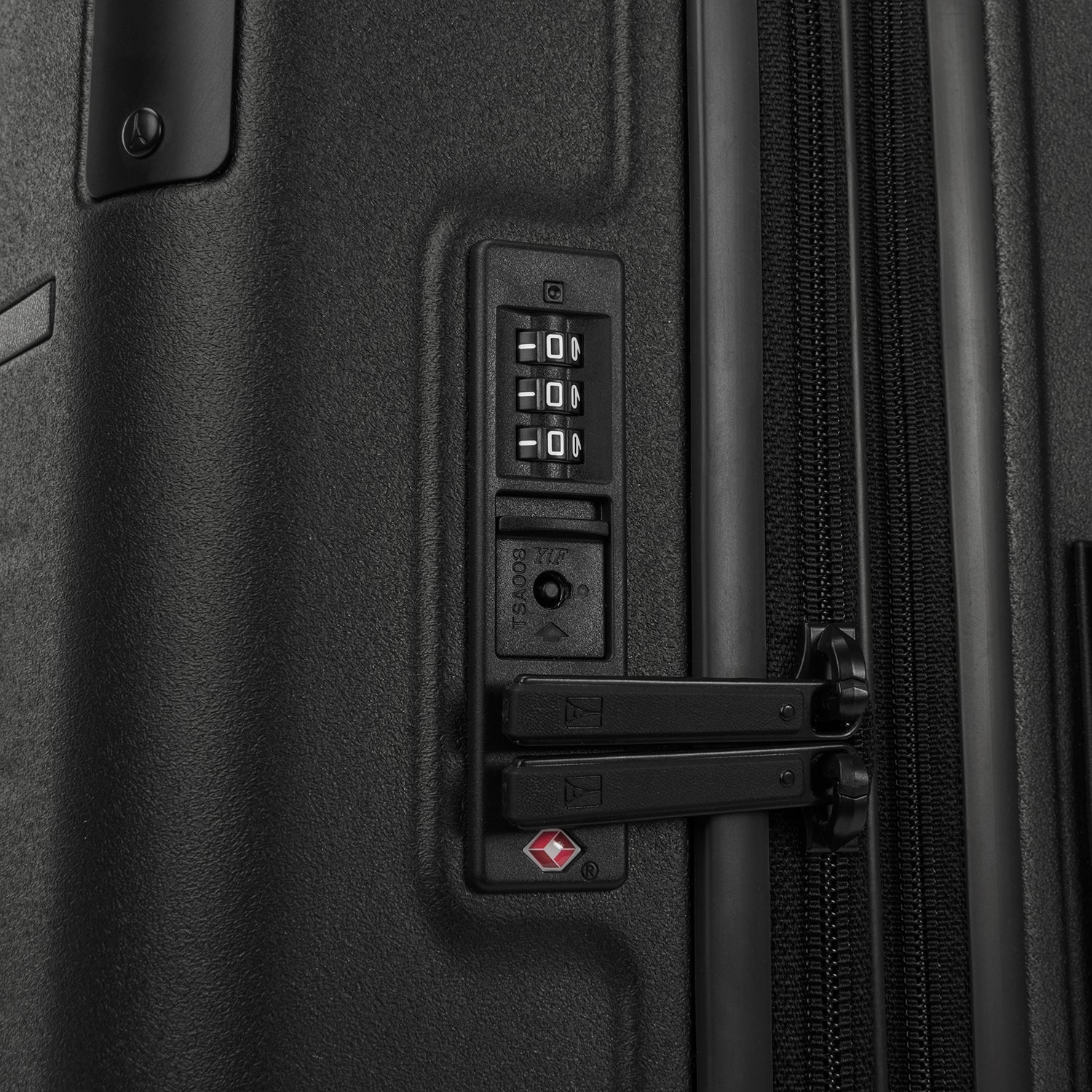 Close-up detail of the Travelpro Platinum Elite Carry-On Hardside Spinner in Jet Black, showing the integrated TSA-approved combination lock and secure zipper pulls on the durable polycarbonate shell.