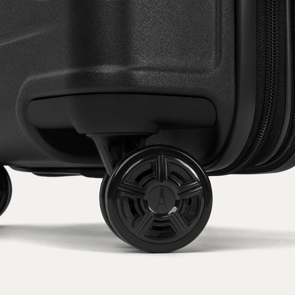 Close-up of the high-performance spinner wheels on the Travelpro Platinum Elite Carry-On Hardside Spinner in Jet Black, featuring self-aligning MagnaTrac® technology for effortless 360-degree mobility.
