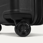Close-up of the high-performance spinner wheels on the Travelpro Platinum Elite Carry-On Hardside Spinner in Jet Black, featuring self-aligning MagnaTrac® technology for effortless 360-degree mobility.