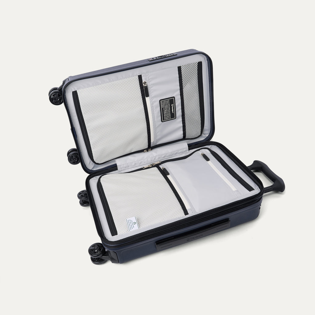 Interior view of the open Travelpro Platinum Elite Compact Carry-On Hardside Spinner in Aviator Navy, featuring dual zippered divider panels and a dedicated internal pocket for FAA-compliant battery storage.