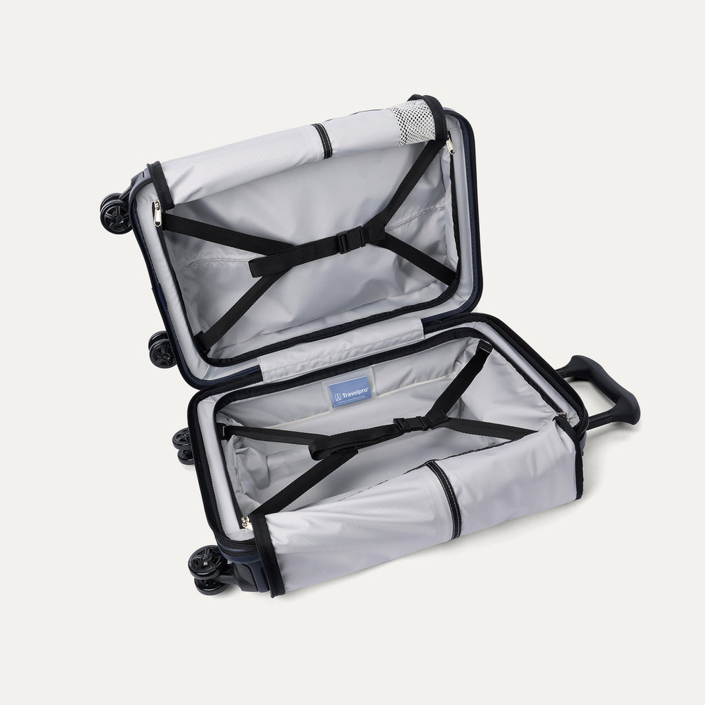 Interior view of the open Travelpro Platinum Elite Compact Carry-On Hardside Spinner in Aviator Navy, featuring dual zippered divider panels and a dedicated internal battery pocket for power bank storage.