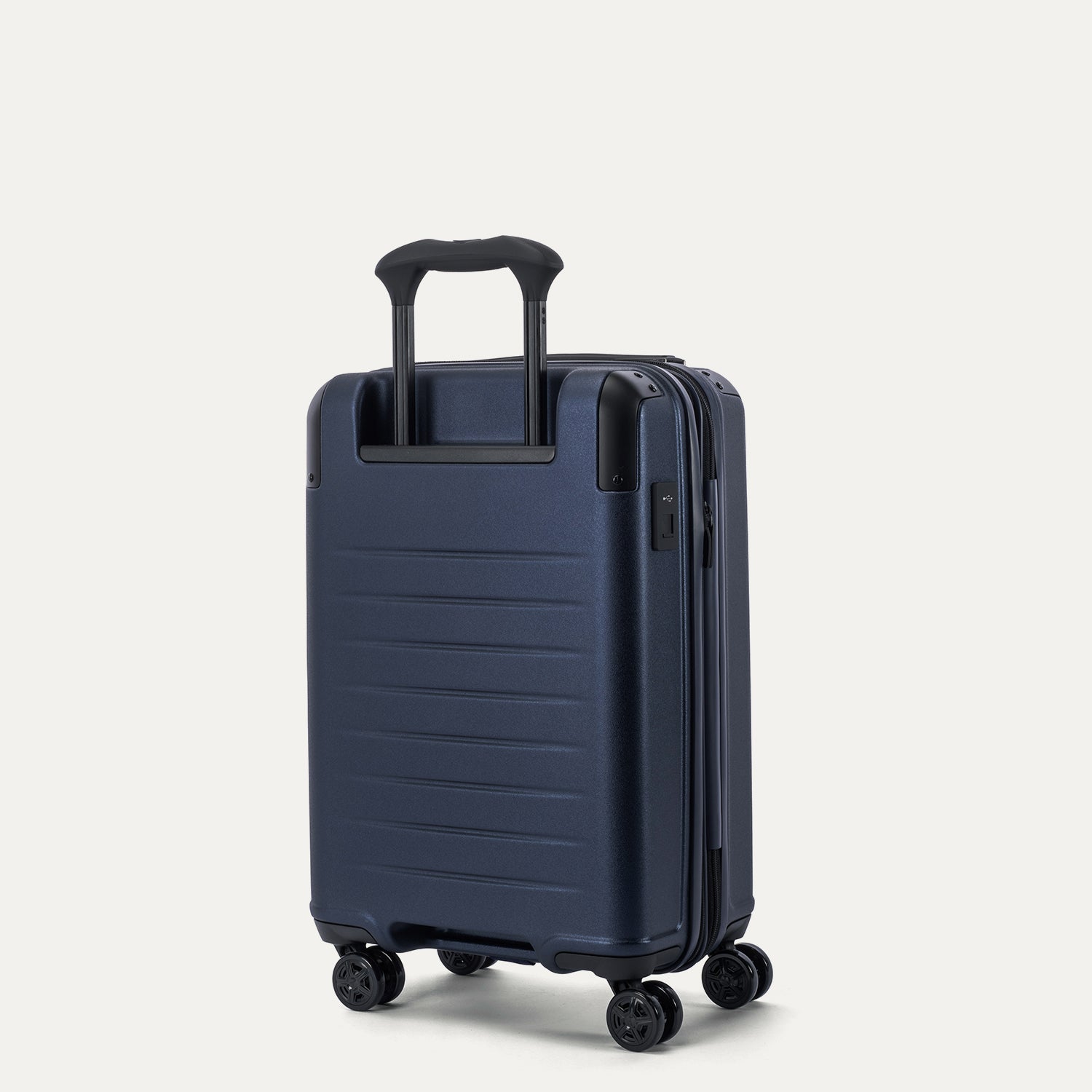 Rear 3/4 view of the Travelpro Platinum Elite Compact Carry-On Hardside Spinner in Aviator Navy, showing the four-stop adjustable PowerScope Lite handle and the durable, textured polycarbonate back panel.