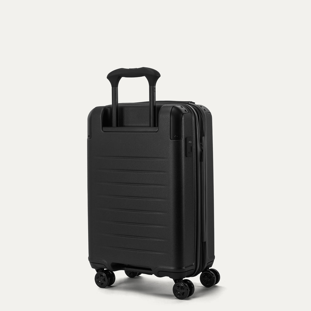 Rear 3/4 view of the Travelpro Platinum Elite Compact Carry-On Hardside Spinner in Jet Black, showcasing the adjustable PowerScope Lite handle and textured polycarbonate shell.
