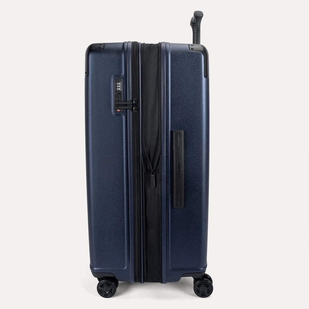 Side profile view of the Travelpro Platinum Elite Large Check-In Hardside Spinner in Aviator Navy, showing the zippered expansion feature that provides 2 inches of additional packing capacity.