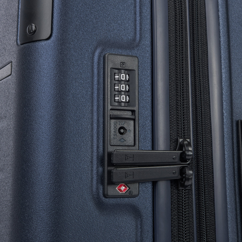 Close-up detail of the Travelpro Platinum Elite Large Check-In Hardside Spinner in Aviator Navy, highlighting the integrated TSA-approved combination lock and zipper pulls for secure travel.