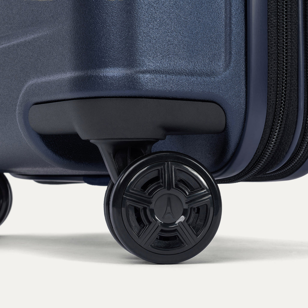 Close-up of the dual spinner wheels on the Travelpro Platinum Elite Large Check-In Hardside Spinner in Aviator Navy, featuring self-aligning MagnaTrac technology for straight tracking and effortless mobility.