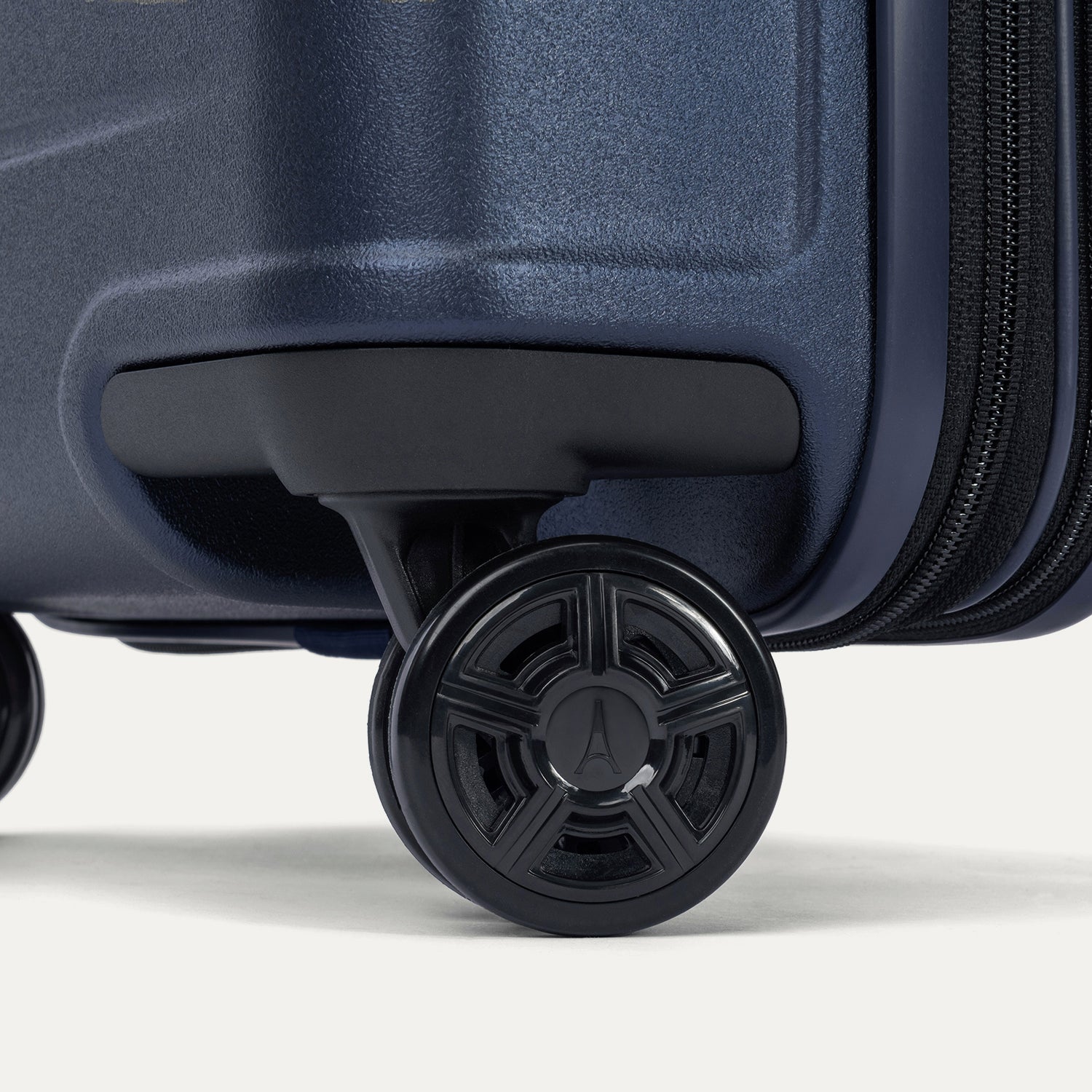 Close-up of the dual spinner wheels on the Travelpro Platinum Elite Large Check-In Hardside Spinner in Aviator Navy, featuring self-aligning MagnaTrac technology for straight tracking and effortless mobility.