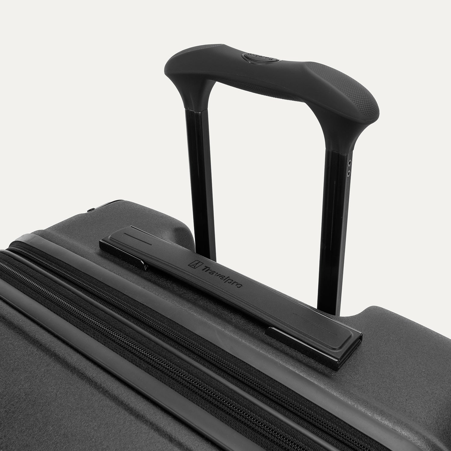 Close-up of the Travelpro Platinum Elite Large Check-In Hardside Spinner in Jet Black, featuring the sturdy PowerScope Lite handle with a comfortable, rubberized Contour Grip.