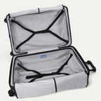 Interior packing view of the open Travelpro Platinum Elite large Check-In Hardside Spinner in Aviator Navy, featuring dual zippered divider panels, adjustable hold-down straps, and ECOFAB recycled lining.