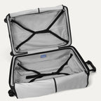 Open interior view of the empty Travelpro Platinum Elite Large Check-In Hardside Spinner in Jet Black, showcasing the spacious dual packing compartments, premium interior lining, and integrated compression straps.