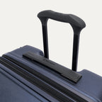Close-up of the Travelpro Platinum Elite Medium Check-In Hardside Spinner in Aviator Navy, featuring the multi-stop PowerScope Lite handle and the sleek, low-profile top carry handle with the Travelpro logo.
