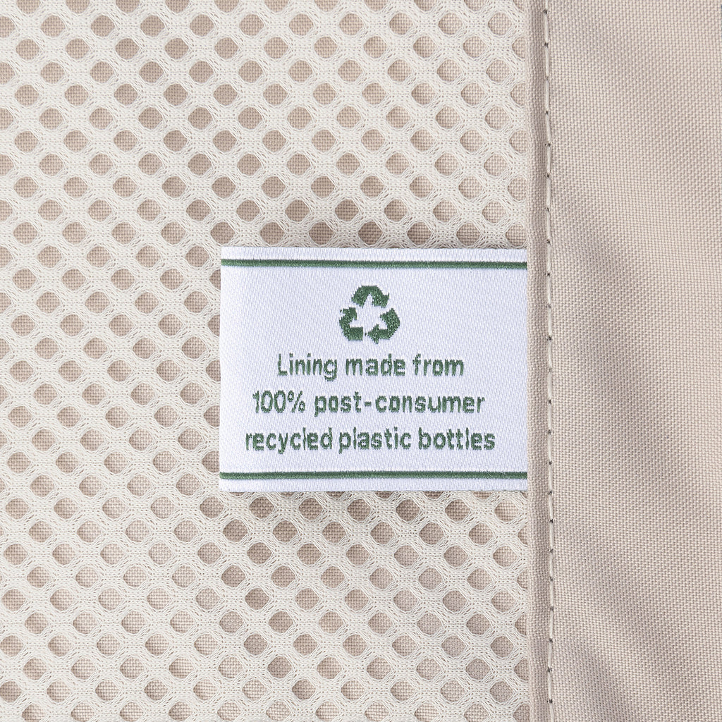 Close-up detail of the ECOFAB™ lining inside the Travelpro Platinum Elite Medium Check-In Hardside Spinner, showing a white fabric label that reads "Lining made from 100% post-consumer recycled plastic bottles" with a green recycling symbol.